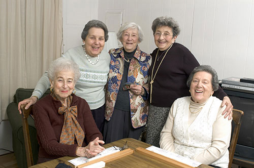 Gruppe ältere Damen steht zusammen und lacht in einer Demenz Wohngemeinschaften