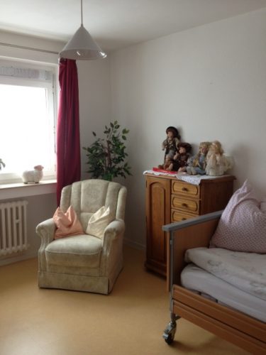 Zimmer mit Sessel und Bett in der Demenzwohngruppen und Demenzwohngemeinschaften Wuppertal Sternenberg